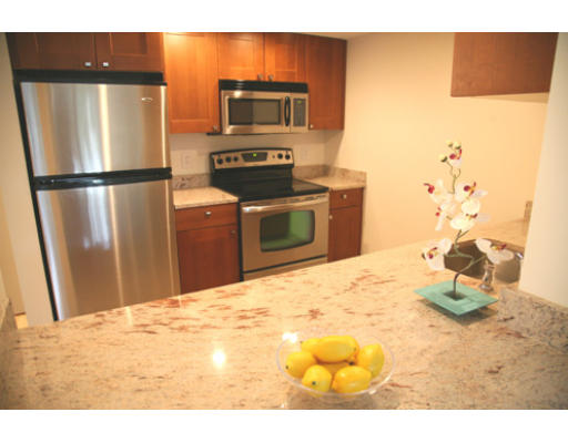 a kitchen with stainless steel appliances granite countertop a refrigerator a stove and a sink with wooden floor