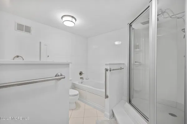 a bathroom with a granite countertop sink a toilet and a shower