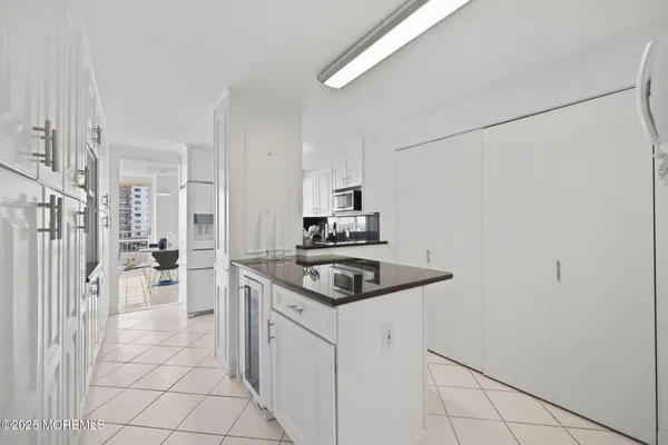 a kitchen with granite countertop white cabinets and a sink