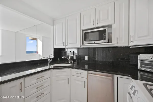 a kitchen with white cabinets and white appliances
