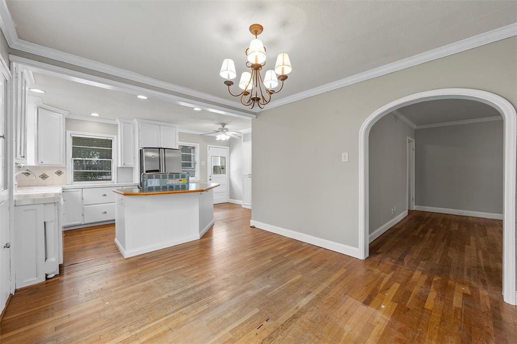2530 Colcord Avenue Waco, TX 76707 - Photo 11 of 23 Kitchen featuring arched walkways, freestanding refrigerator, ceiling fan, white cabinets, and tasteful backsplash