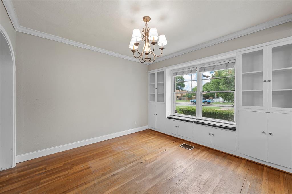 2530 Colcord Avenue Waco, TX 76707 - Photo 13 of 23 Empty room with wood-type flooring, a chandelier, ornamental molding, and baseboards