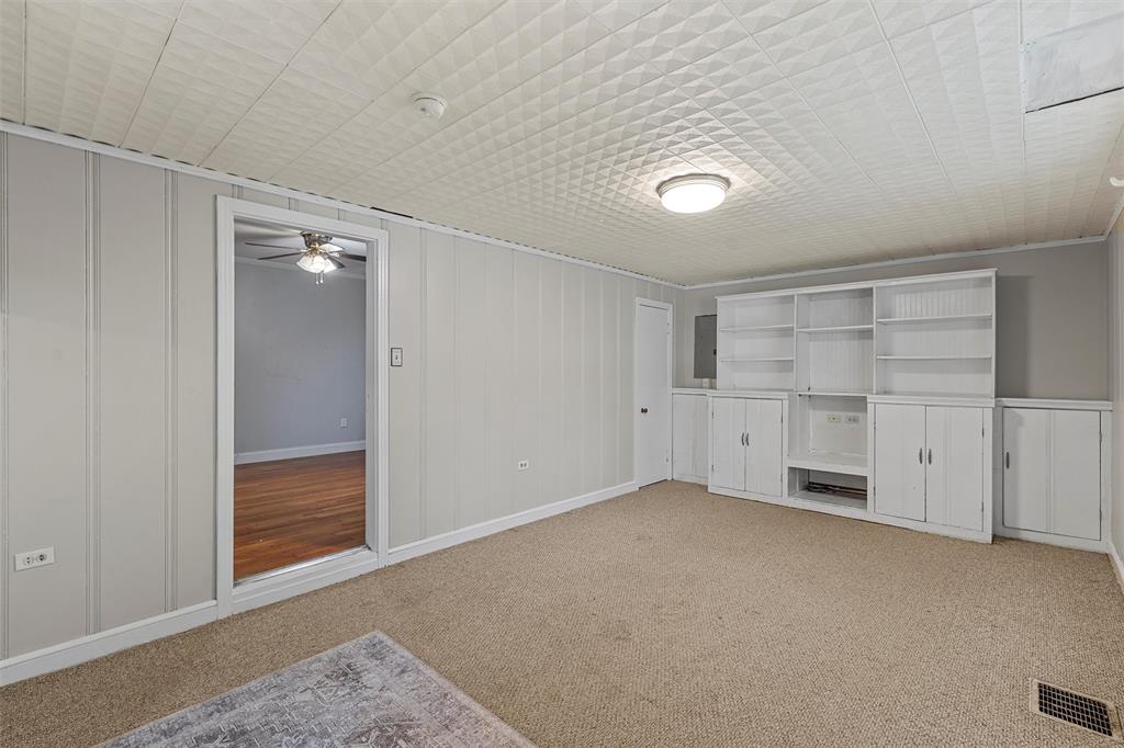 2530 Colcord Avenue Waco, TX 76707 - Photo 18 of 23 Unfurnished living room featuring light carpet, a ceiling fan, a decorative wall, electric panel, and baseboards