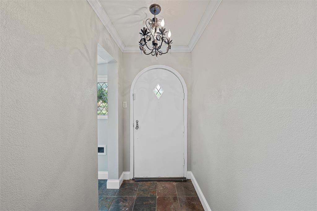 2530 Colcord Avenue Waco, TX 76707 - Photo 4 of 23 Entryway featuring stone tile flooring, baseboards, a chandelier, crown molding, and a textured wall