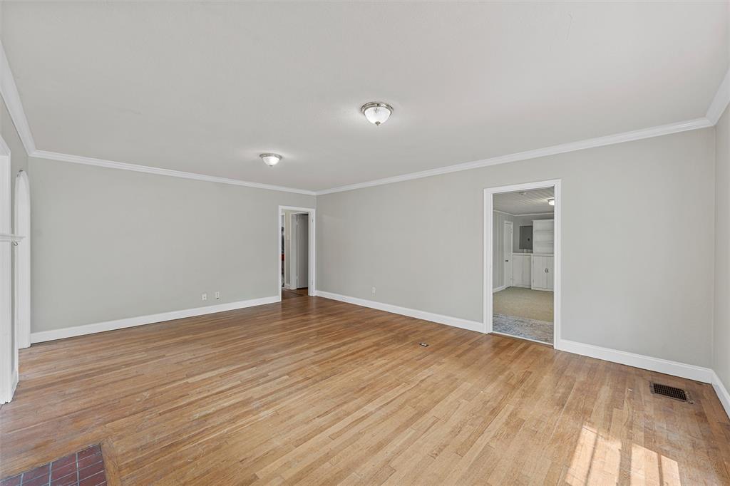 2530 Colcord Avenue Waco, TX 76707 - Photo 6 of 23 Spare room featuring baseboards, light wood finished floors, and ornamental molding
