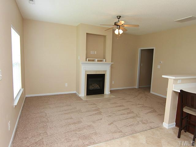 678 Citrus Petal Road Fuquay-Varina, NC 27526 - Photo 14 of 14 a view of an empty room with a fireplace and a window