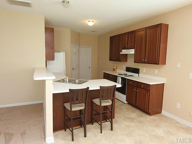 678 Citrus Petal Road Fuquay-Varina, NC 27526 - Photo 3 of 14 a kitchen with granite countertop a sink cabinets and stove top oven