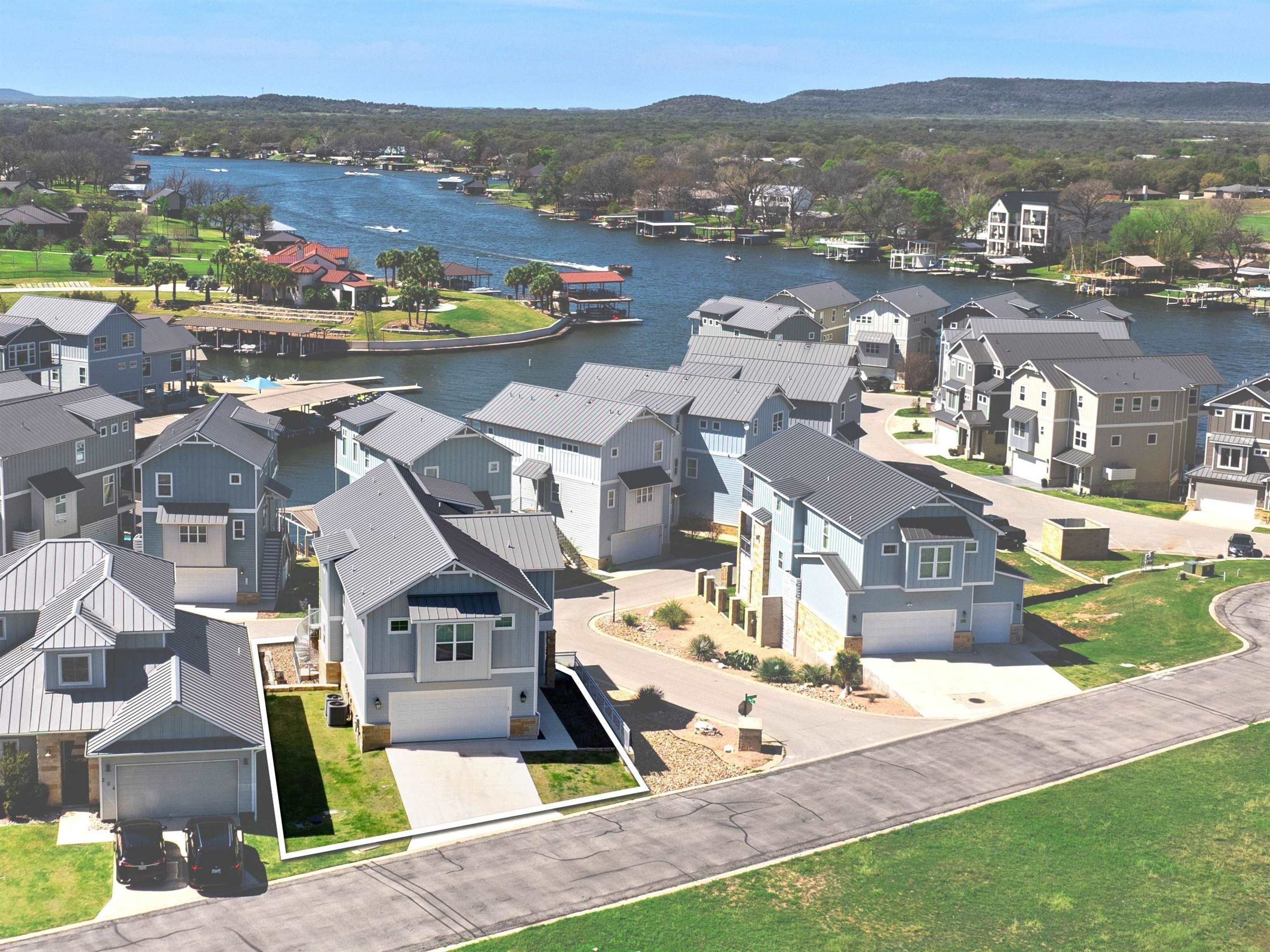 an aerial view of residential houses with outdoor space and ocean view