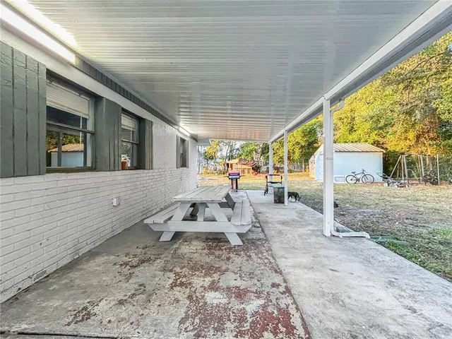 a view of a house with backyard and sitting area