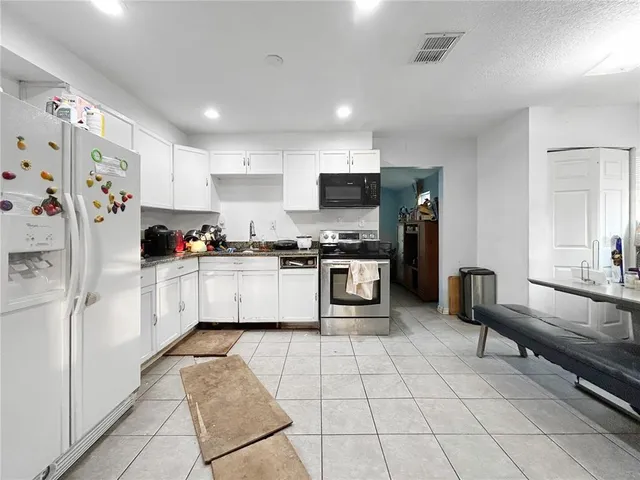 a kitchen with stainless steel appliances a refrigerator sink and cabinets