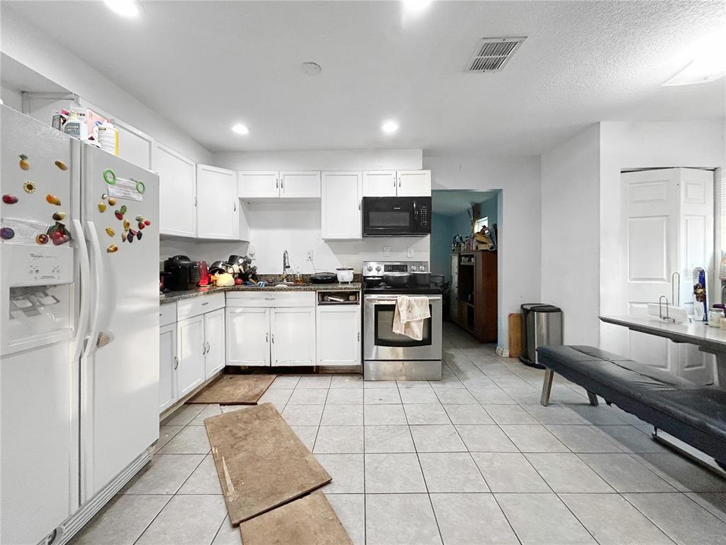 17447 Bathurst Avenue Spring Hill, FL 34610 - Photo 2 of 19 a kitchen with stainless steel appliances a refrigerator sink and cabinets