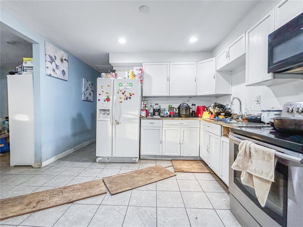 17447 Bathurst Avenue Spring Hill, FL 34610 - Photo 3 of 19 a kitchen with stainless steel appliances granite countertop a refrigerator and a sink