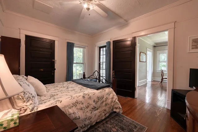 a bedroom with a bed a fireplace and a large window