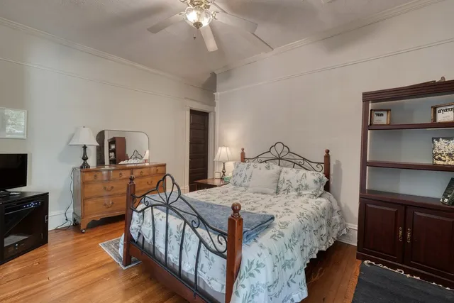 a bedroom with a bed and a dresser with mirror
