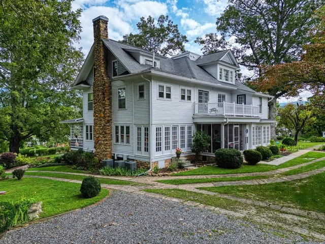 a front view of a house with a yard and potted plants