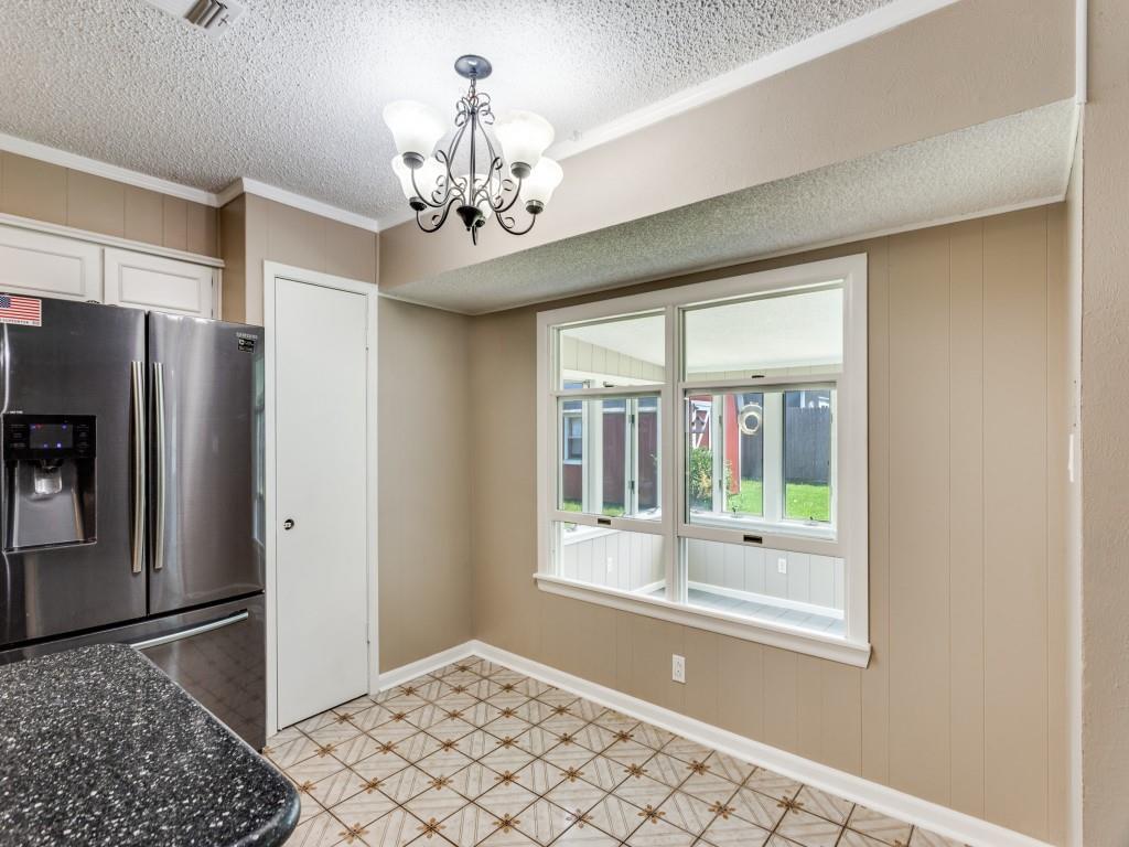 1216 Manning Street Benbrook, TX 76126 - Photo 7 of 26 Kitchen featuring stainless steel fridge with ice dispenser, hanging light fixtures, ornamental molding, a chandelier, and a textured ceiling