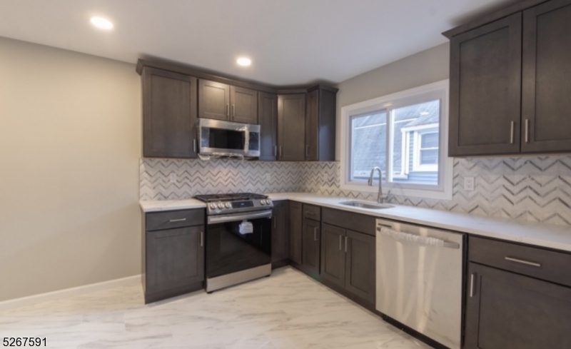 35 Watson Avenue, Unit 2 West Orange, NJ 07052 - Photo 2 of 6 a kitchen with stainless steel appliances granite countertop a sink stove and microwave