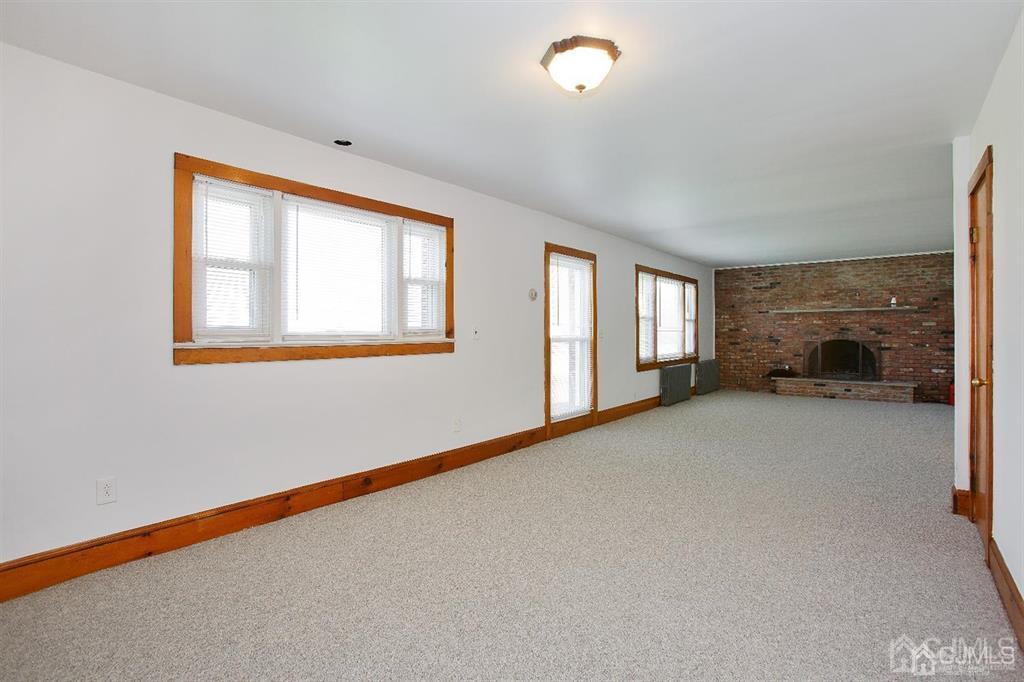 173 Cottrell Road Old Bridge, NJ 07747 - Photo 12 of 28 an empty room with fireplace and windows