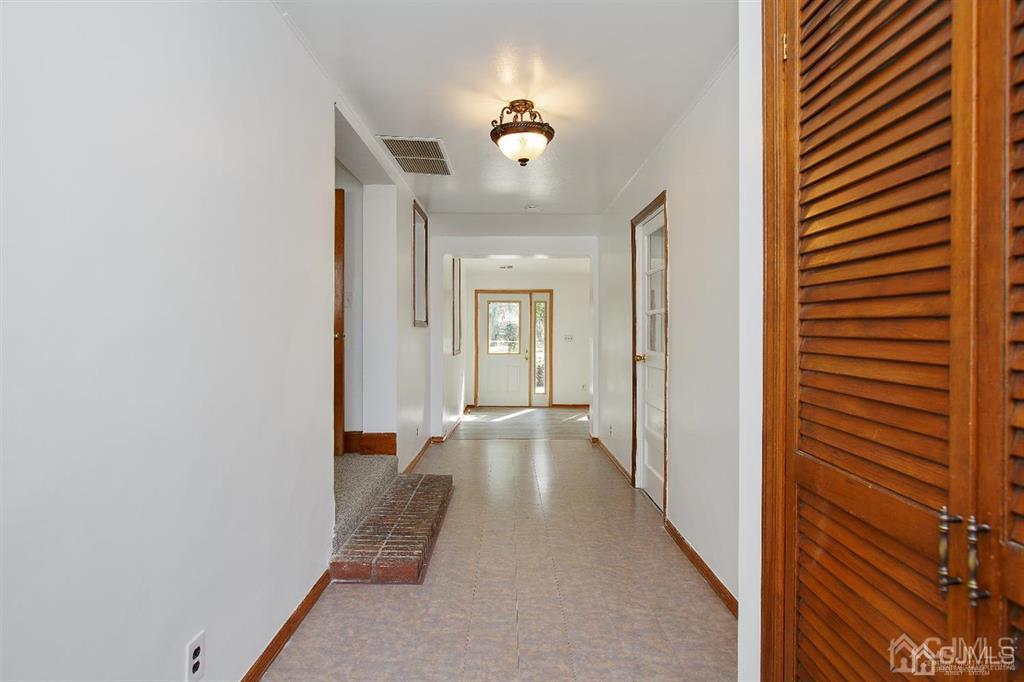 173 Cottrell Road Old Bridge, NJ 07747 - Photo 10 of 28 a view of a hallway with wooden floor and a bathroom