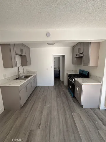 a kitchen with sink a stove and cabinets