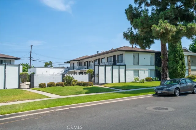 a view of a house with a big yard and large trees