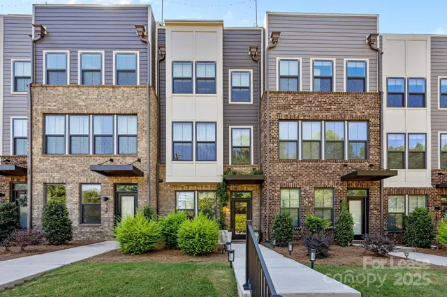 a front view of a building with plants and entryway