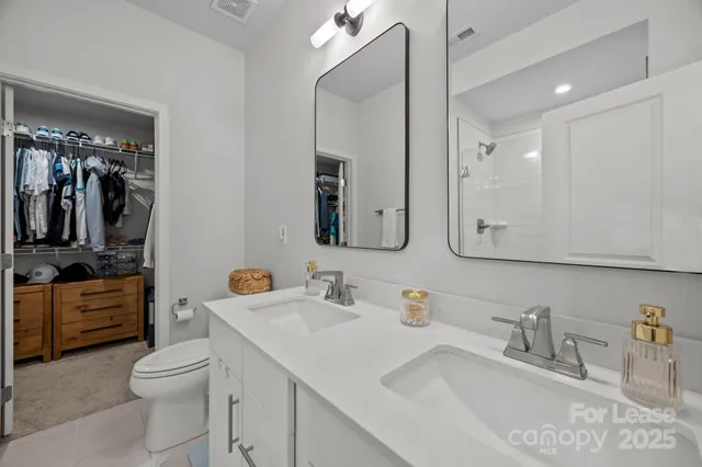 a bathroom with a toilet a sink a vanity and mirror