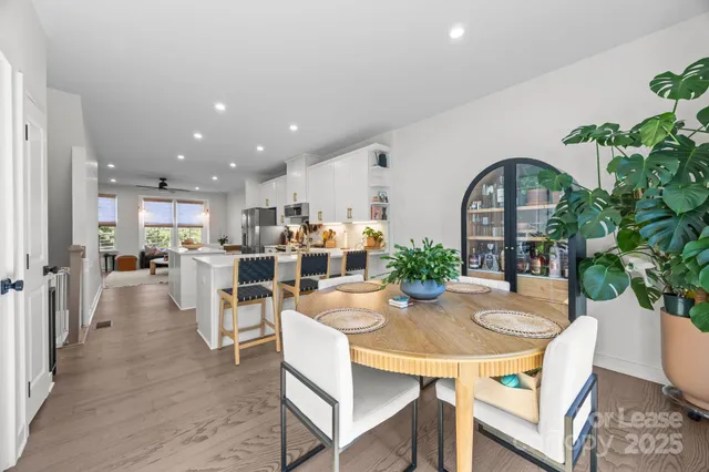 a dining room with furniture potted plants and wooden floor