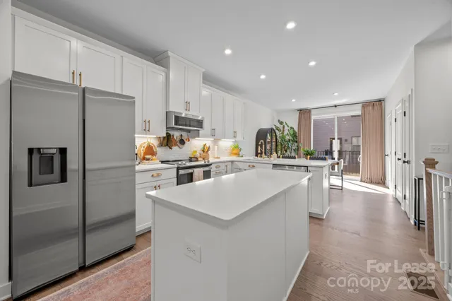 a kitchen with white cabinets and stainless steel appliances