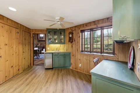 a kitchen with a wooden floor and large window