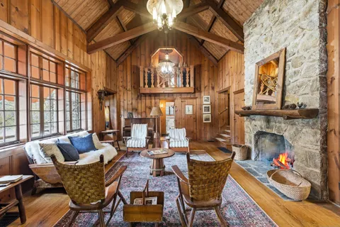 a living room with furniture a fireplace and a floor to ceiling window