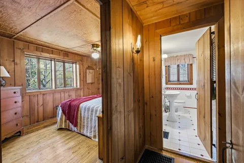 a view of a bedroom with wooden floor and windows