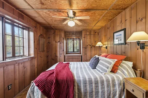 a bedroom with a bed a chandelier and a window