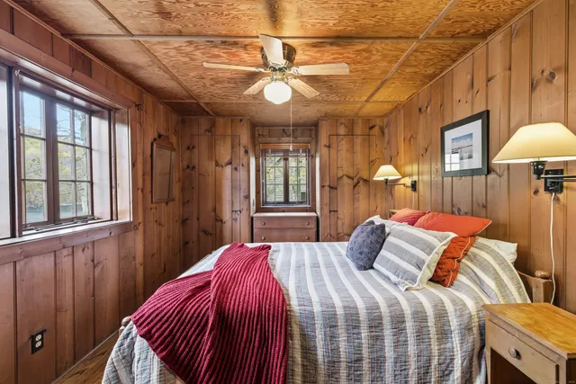 a bedroom with a bed a chandelier and a window