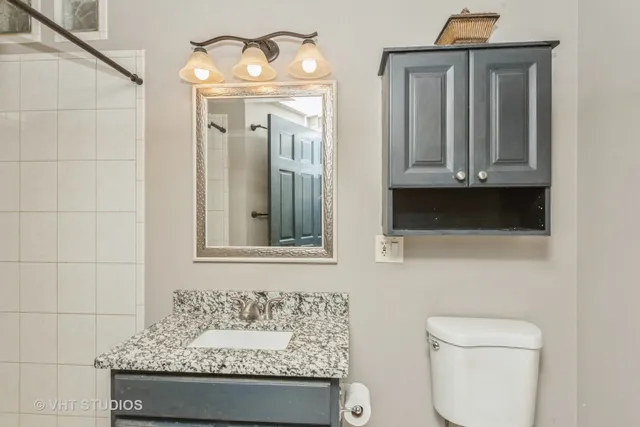 a bathroom with a toilet sink and mirror
