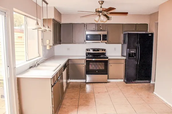 a kitchen with stainless steel appliances granite countertop a refrigerator stove top oven and sink