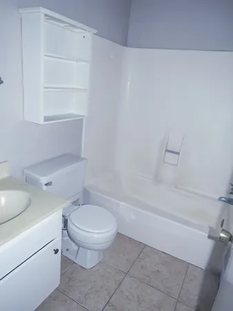 a white toilet sitting next to a bath tub