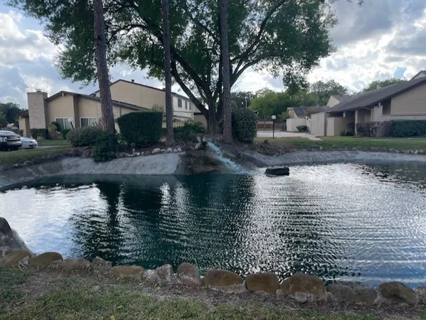 a view of a house with yard and lake view