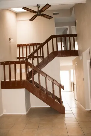 a view of staircase with lots of frames on wall and a window