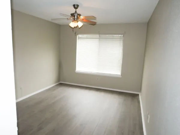 an empty room with wooden floor and window