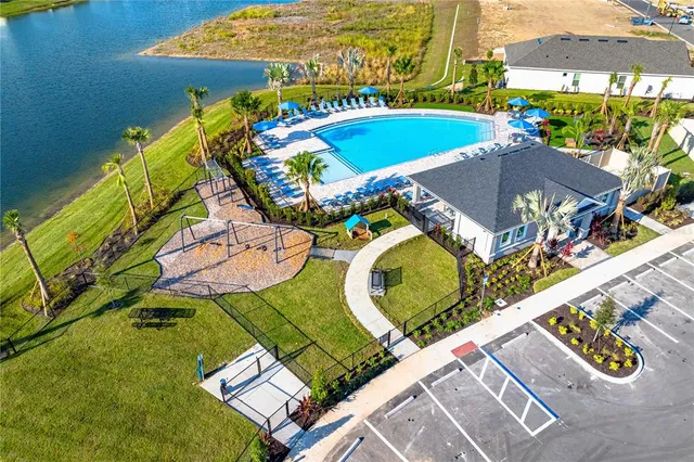 an aerial view of a swimming pool with outdoor seating