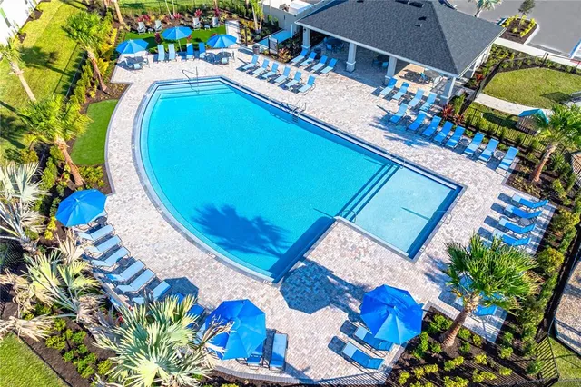 a view of a swimming pool with a table and chairs under an umbrella