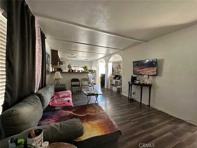 a living room with furniture and a flat screen tv with wooden floor