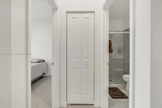 a walk in closet with view of bedroom