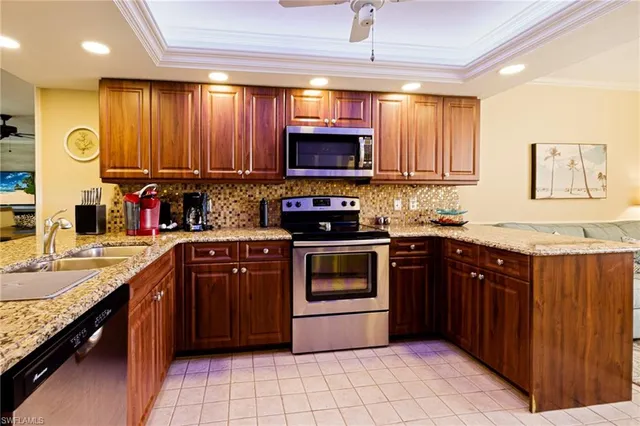 a kitchen with stainless steel appliances granite countertop a stove a sink and a microwave