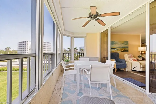 a dining room with furniture water view and a floor to ceiling window