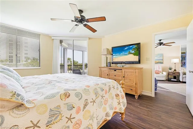 a bedroom with a bed and a flat tv screen on dresser