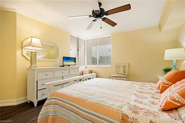 a bedroom with a bed a dresser and a chandelier