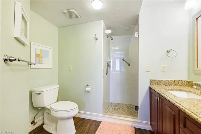 a bathroom with a granite countertop sink toilet and shower