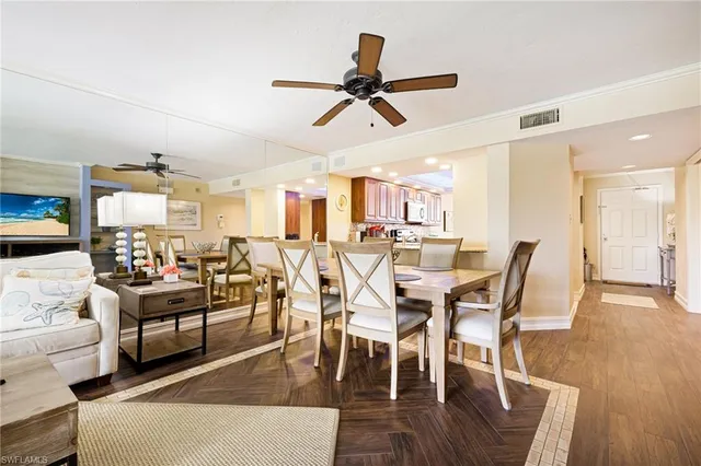 a view of a dining room and livingroom with furniture a rug a fireplace and a chandelier